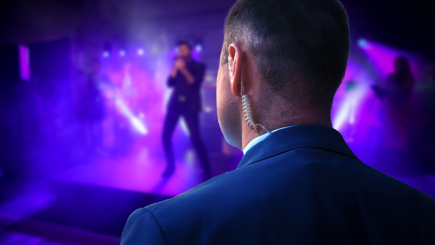Security officer with earpiece watching over a concert