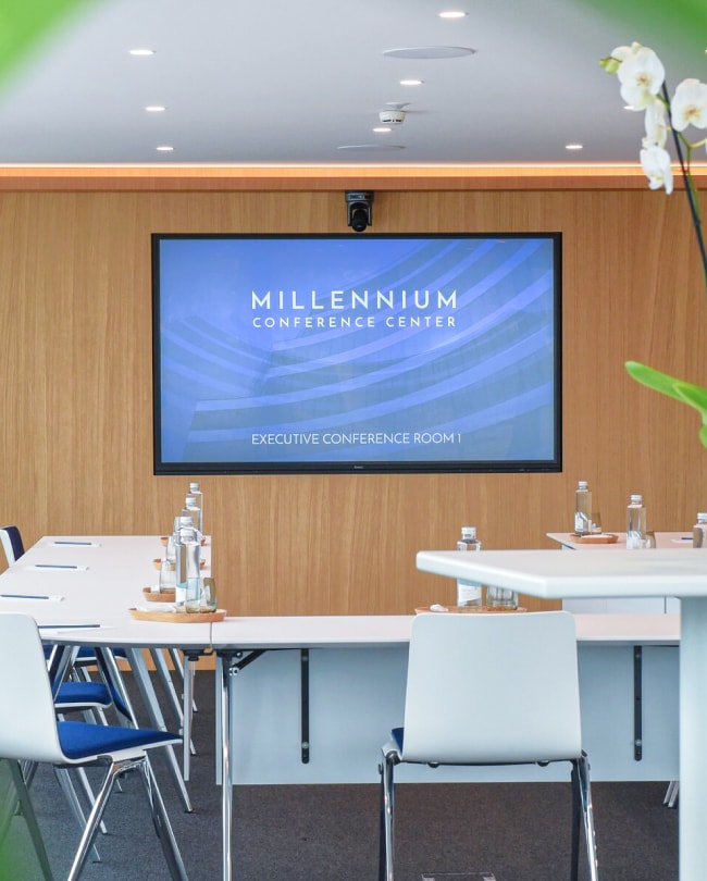 Executive Conference Center room in U-shape with screen and orchids