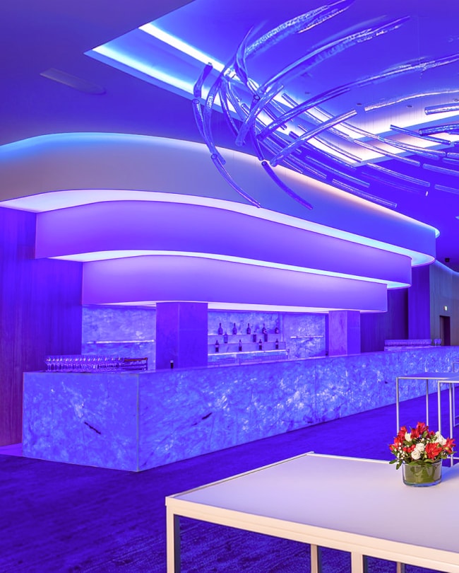 The 20-metre backlit bar in The Space under purple lighting