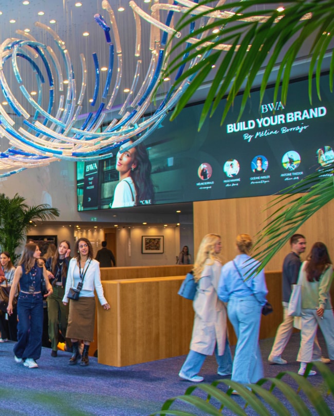 Event attendees in the Lobby, light sculpture and LED screen