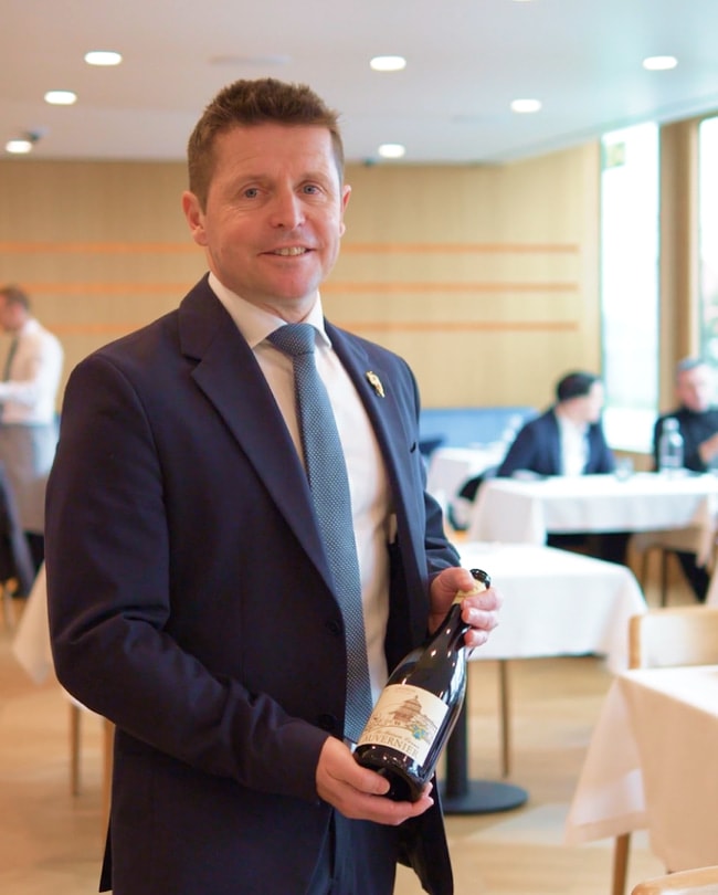 Millennium sommelier presenting a bottle of wine