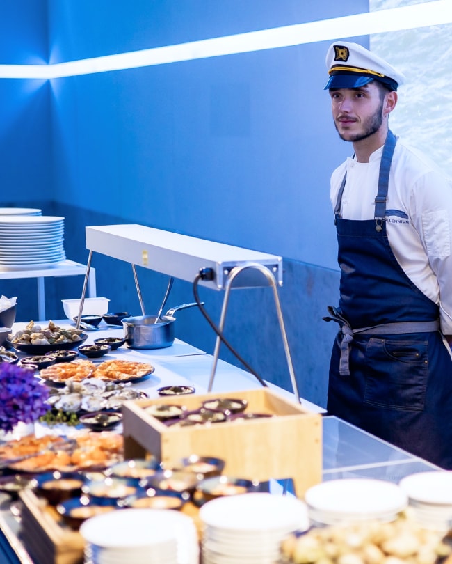 Live cooking station: chef in sailor outfit behind a seafood buffet