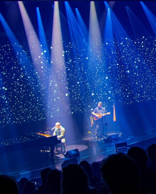 Concert piano-guitare sur La Scène sous des faisceaux et un ciel étoilé LED