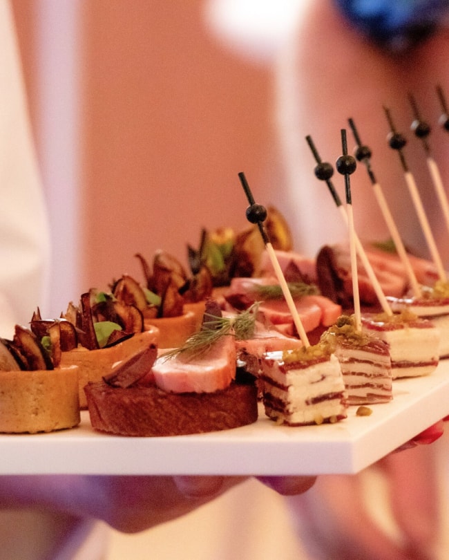 Serveur présentant un plateau d’amuse-bouches lors d’une réception